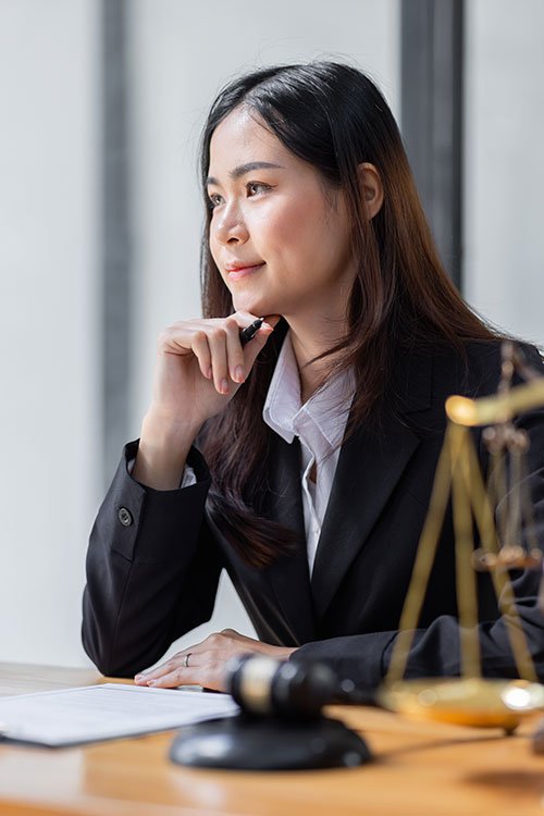 Woman in suit at desk with gavel