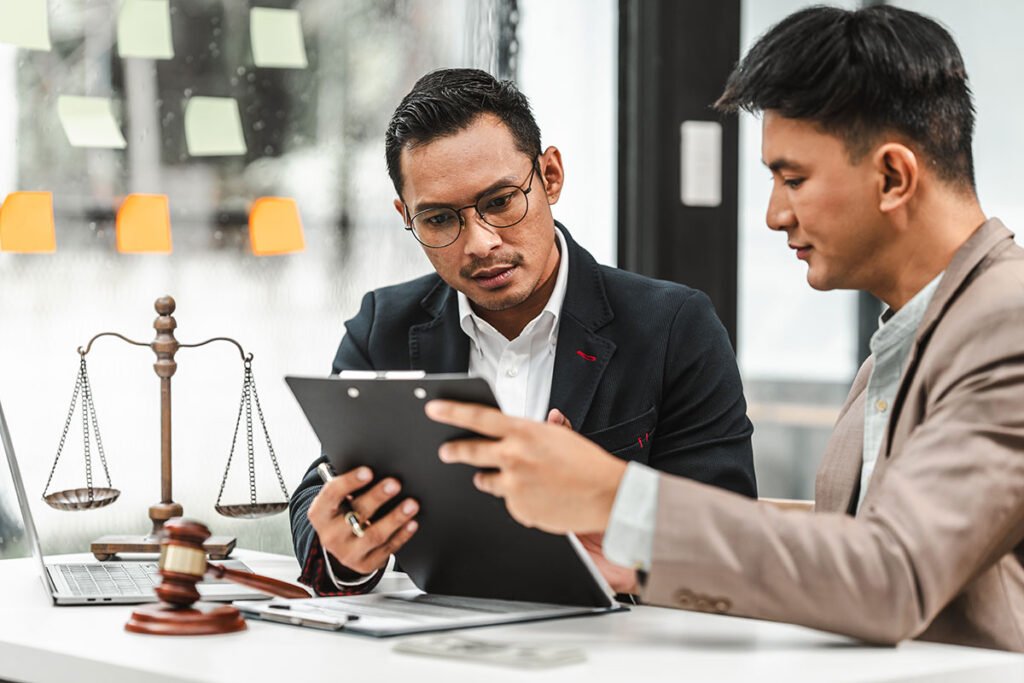 Two professionals reviewing legal documents at desk