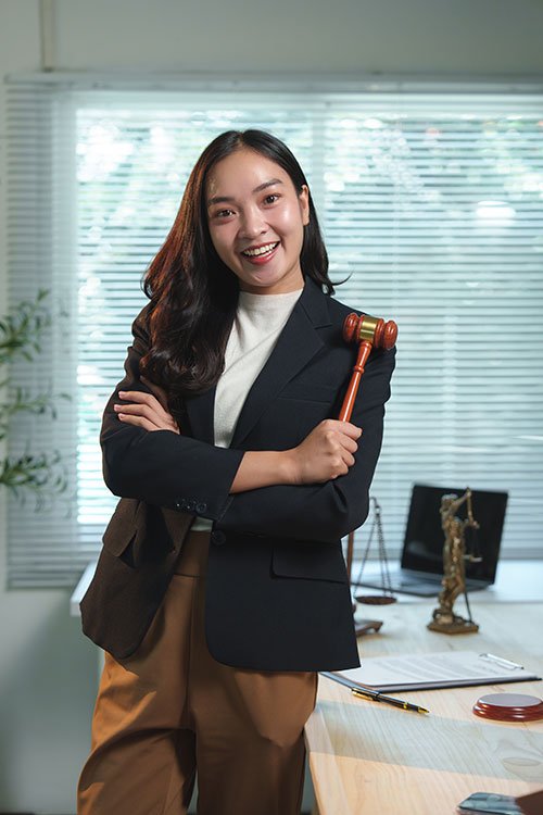 Smiling professional holding gavel in office