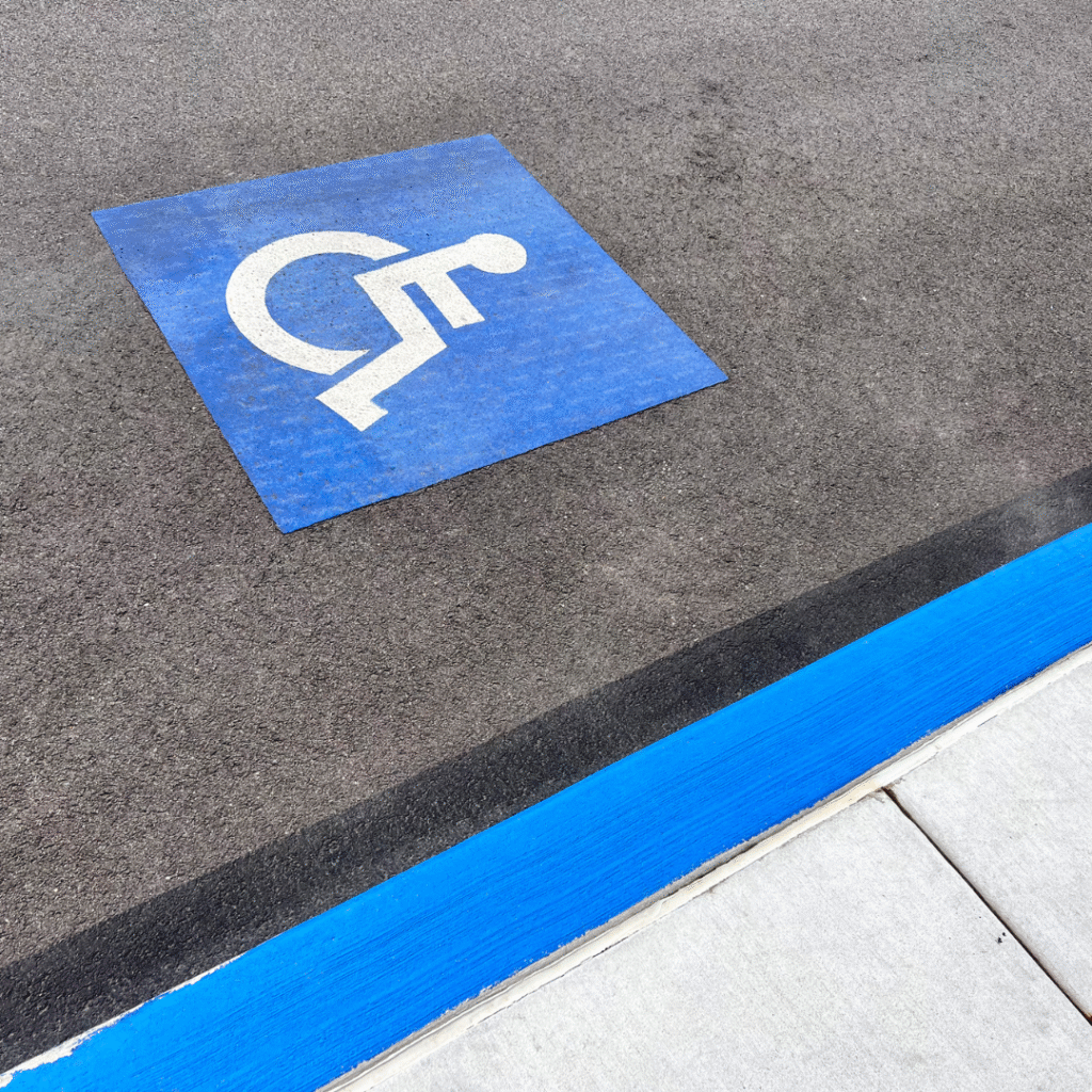 Wheelchair accessible parking symbol on pavement