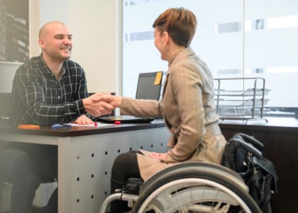 Man and woman shaking hands, woman in wheelchair